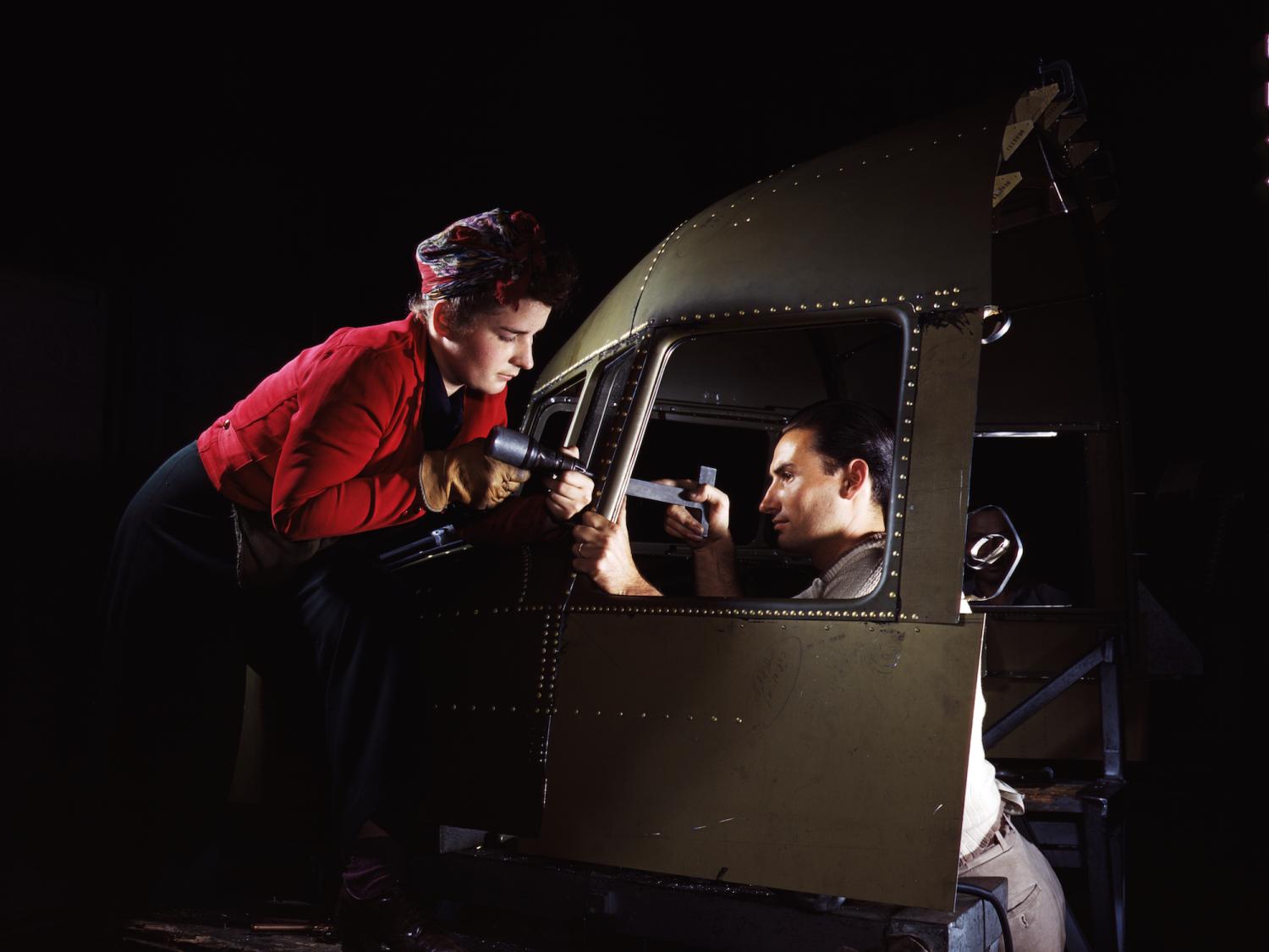 A man and woman riveting team working on the cockpit shell of a C-47 aircraft at the plant of North American Aviation, 1942.