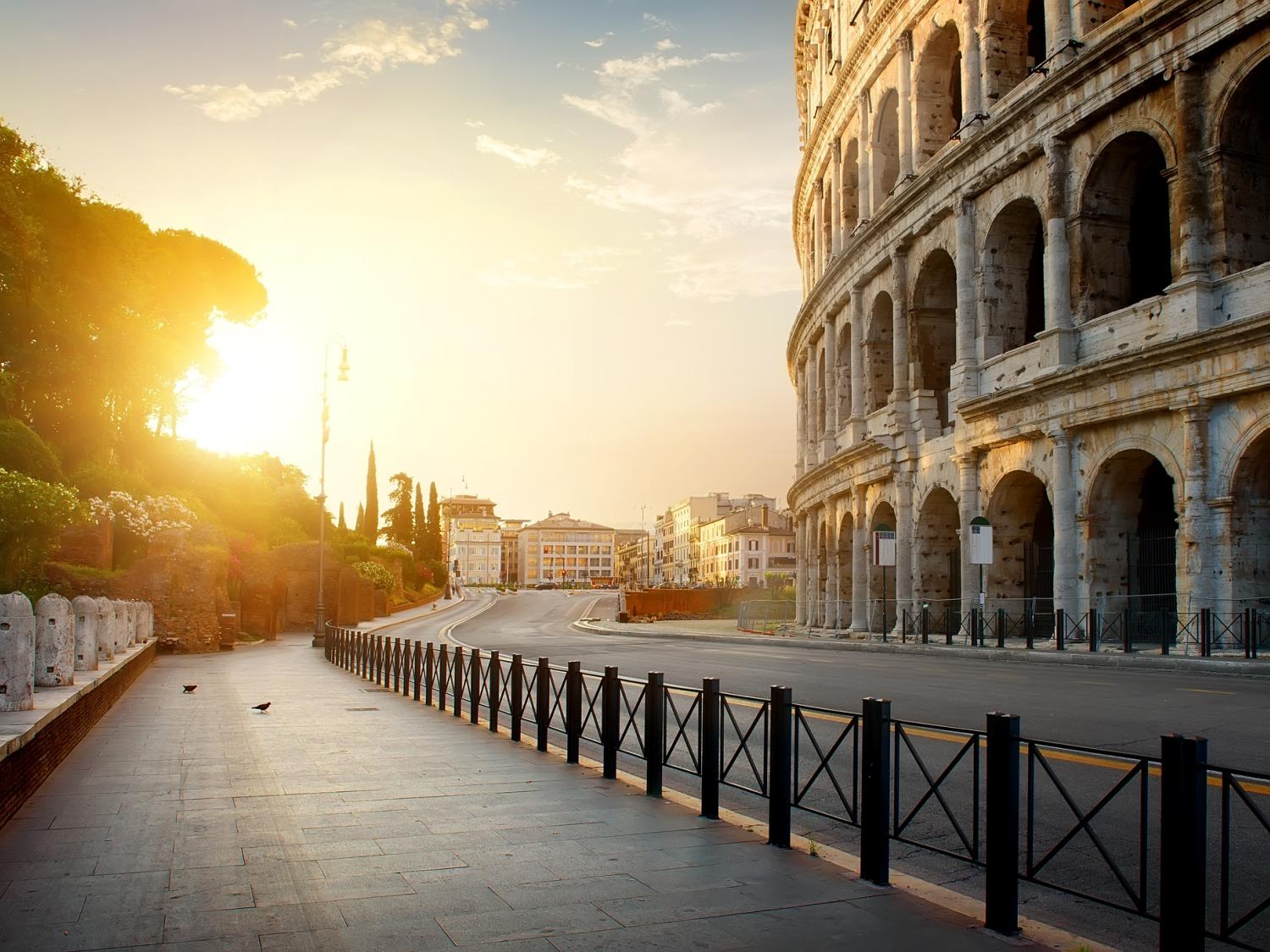 View of the roman colosseum with the sun setting in the distance