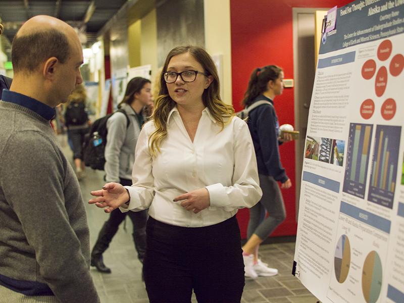 Courtney Rome, a senior majoring in geography, discusses her first-place-winning poster with Guido Cervone, associate professor in the Department of Geography and Institute for CyberScience.