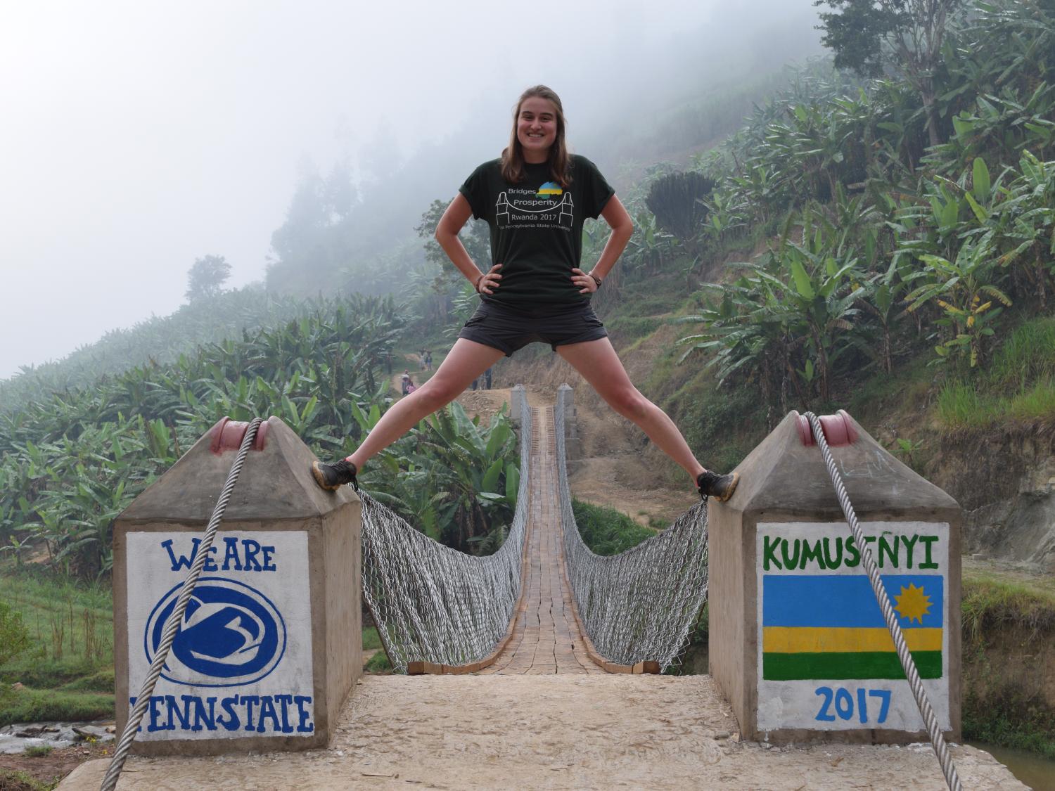 college student poses on footbridge in Rwanda