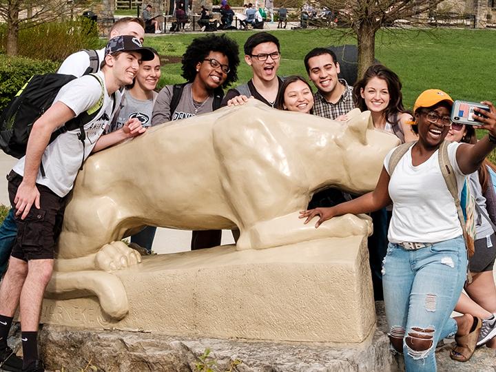 Students taking a selfie in front of the lion shrine.