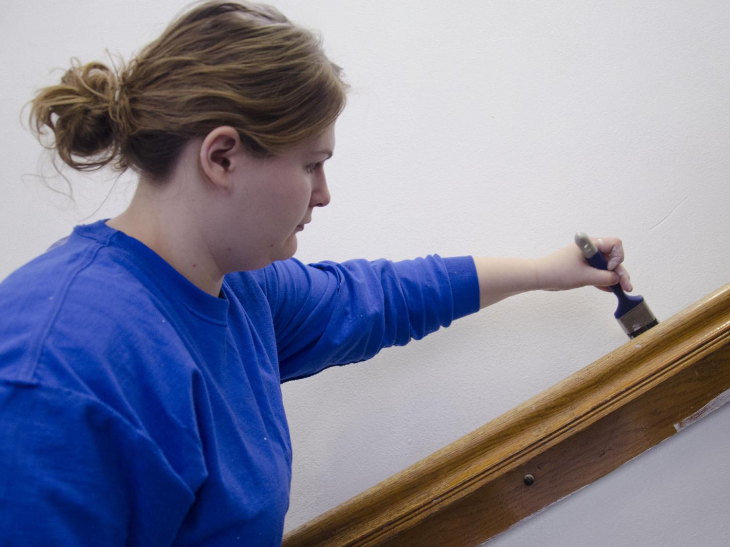 A student painting a staircase 