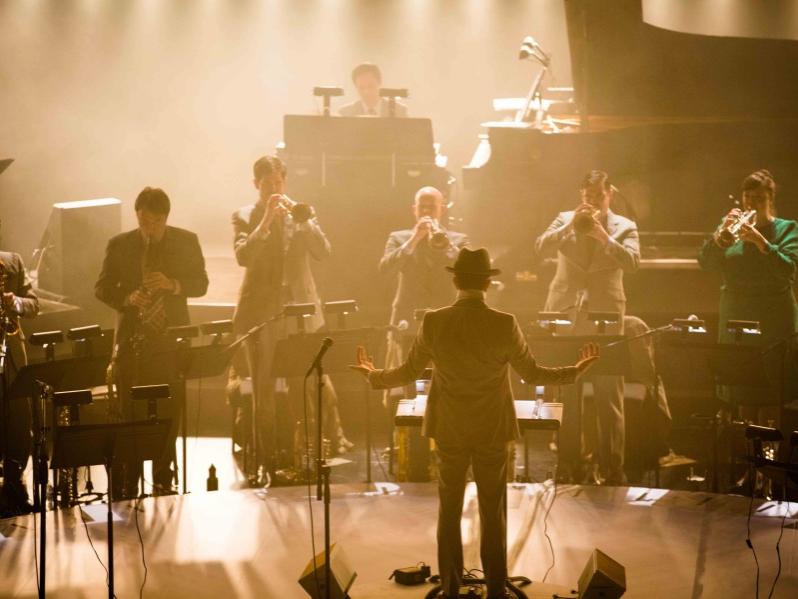 Musicians perform on a foggy stage.