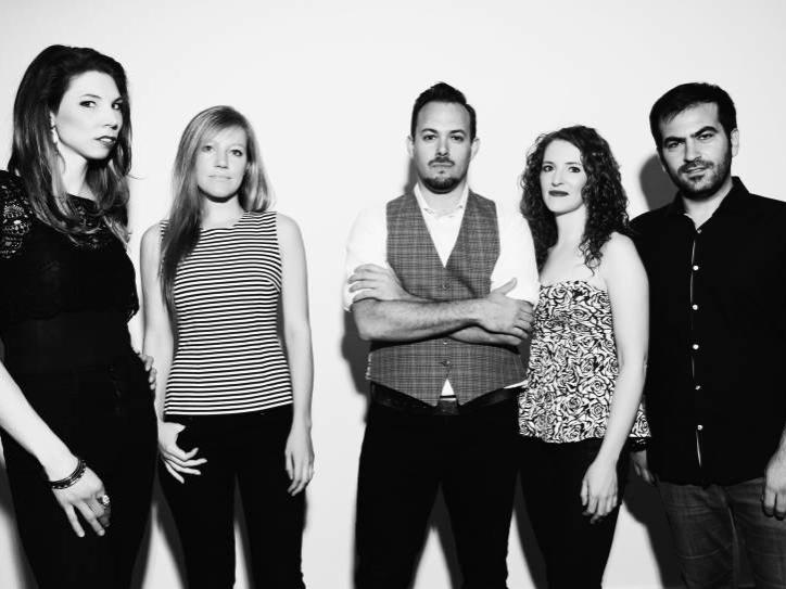 The members of Sybarite5 pose for a photo while standing against a wall.