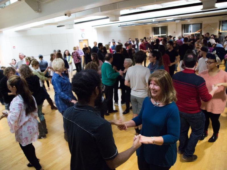 Couples face each other while they learn salsa dance moves.