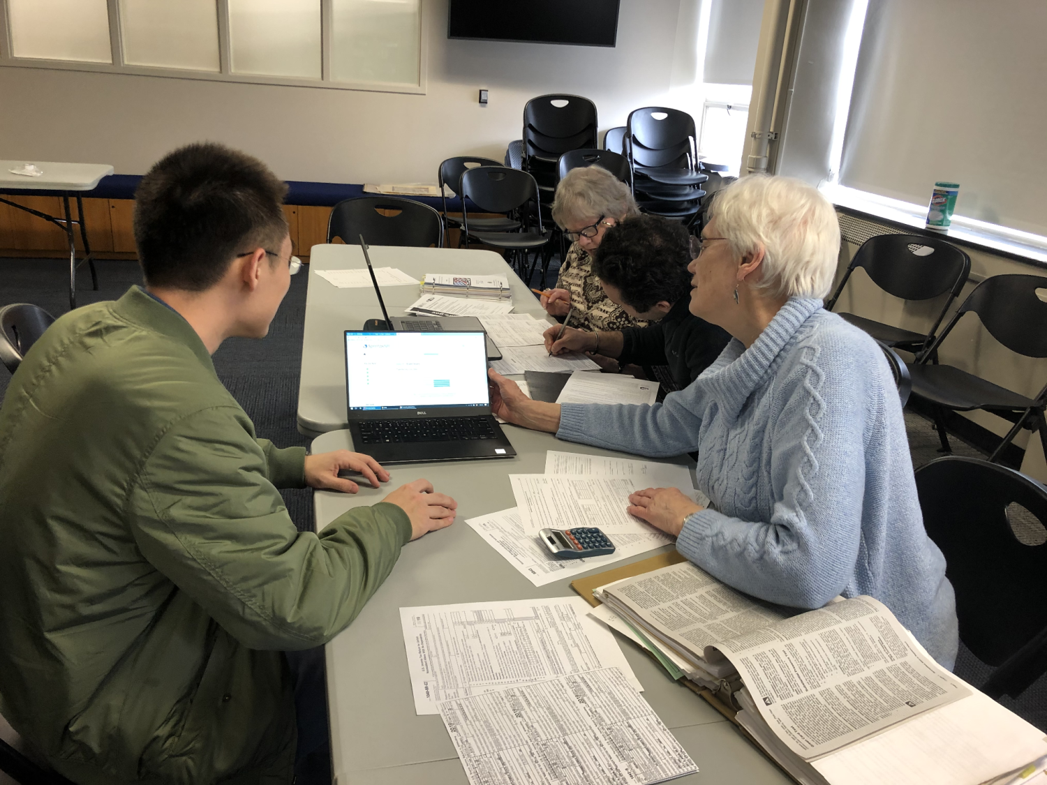 A volunteer helps a student learn about the tax system