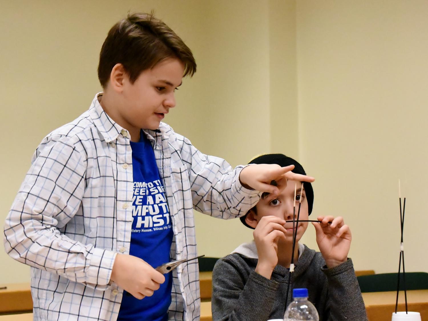 Ryker Selnekovic, left, and Killian Radel, both seventh-grade students in the Brookville Area School District, work to perfect their bridge during the Mystery Architecture activity at the 2019 regional Science Olympiad. 