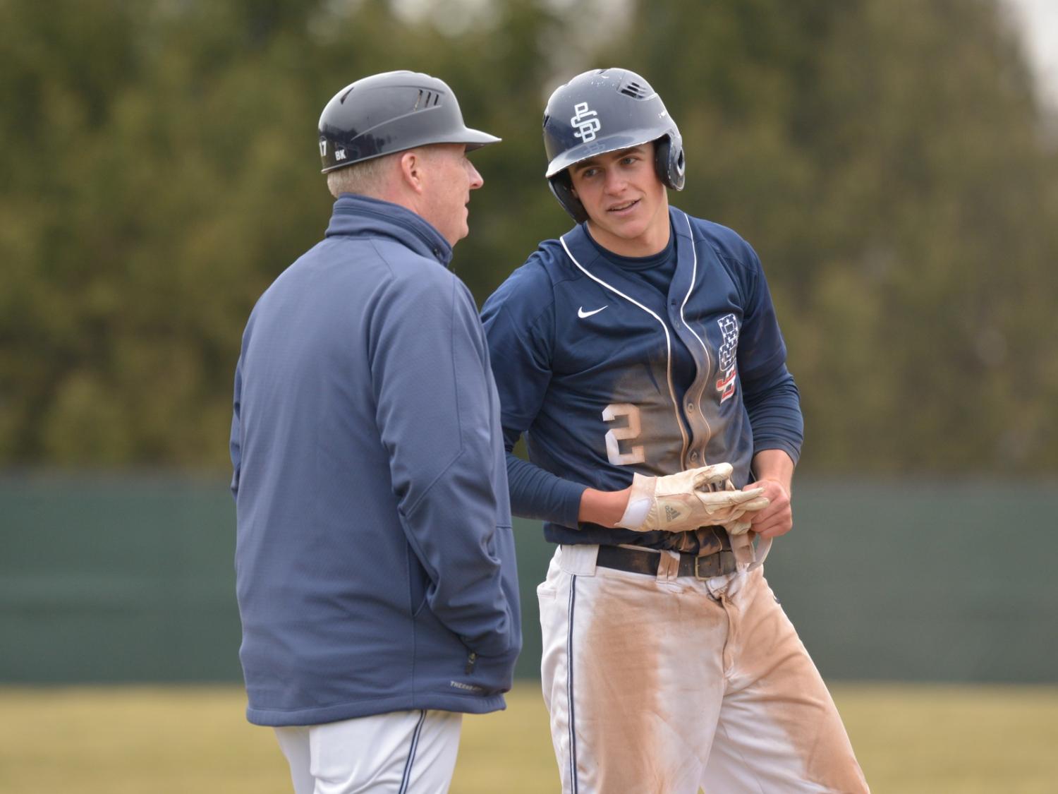 Penn State Behrend baseball player Scott Sada talks with his coach while on base.