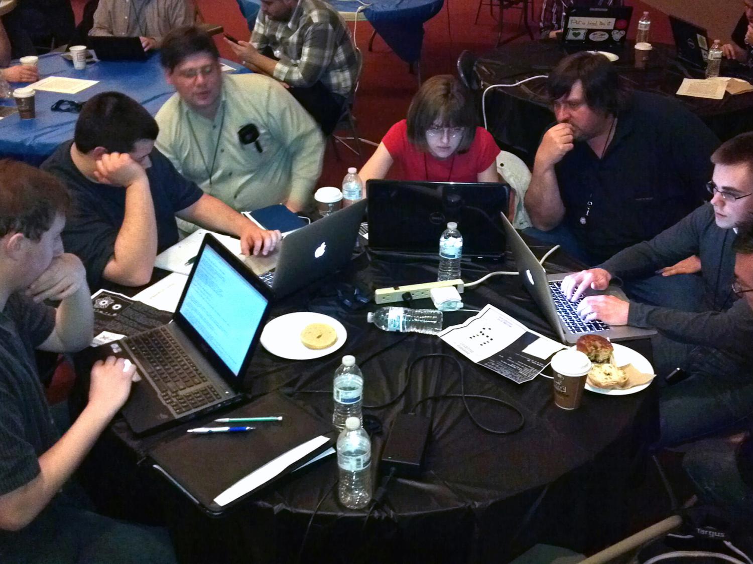 Penn College students working at a table with their faculty mentors
