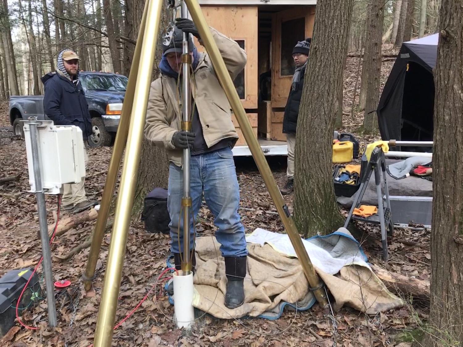 Researchers remove a seismic logging instrument from a borehole at Shale Hills.