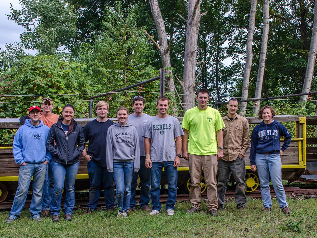 students posing in front of mine carts