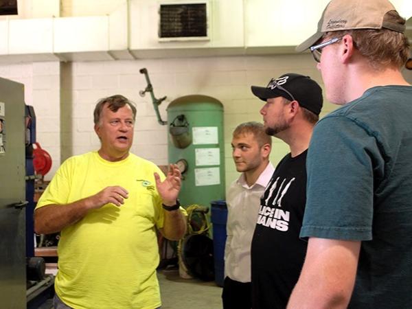 Four men standing together inside local sewer plant