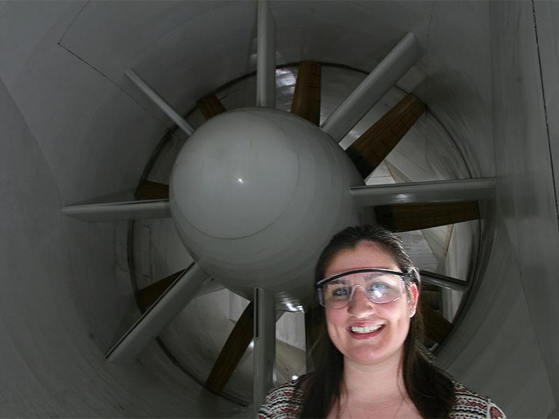 young woman standing in front of wind tunnel