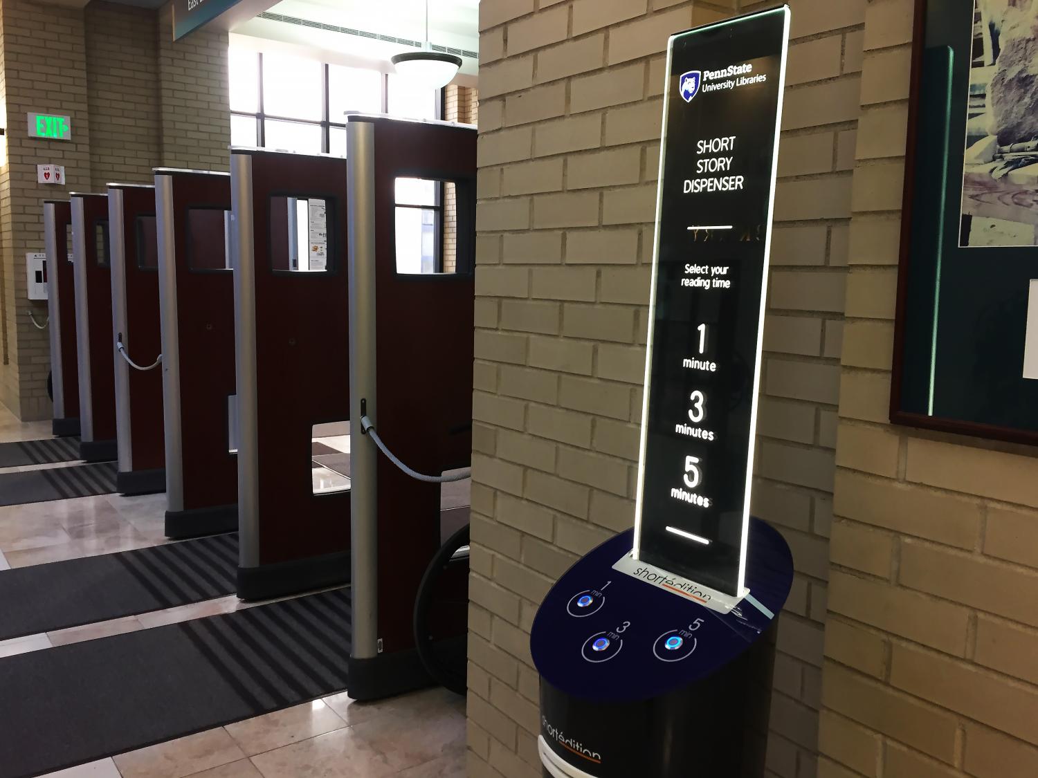 Short Edition blue short story dispenser near Penn State Paterno Library entrance security gates