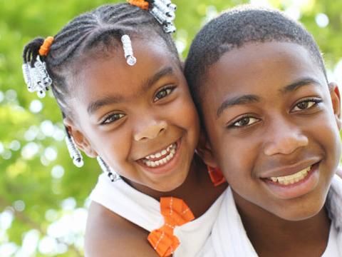 An adolescent brother and sister hugging