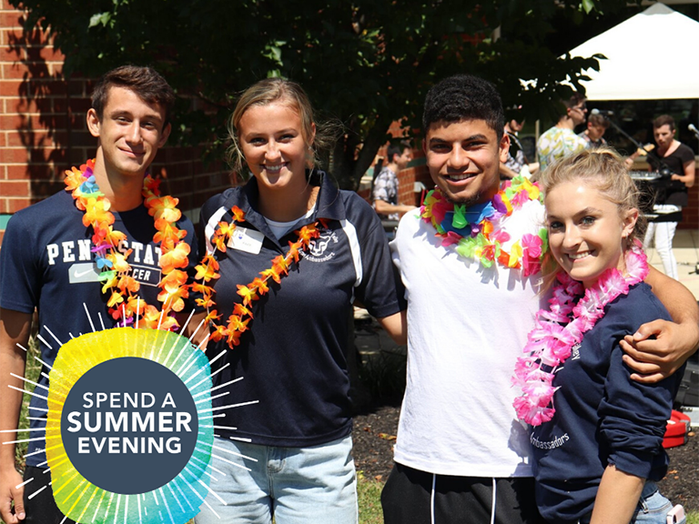 Four smiling students standing outside arm-in-arm on campus