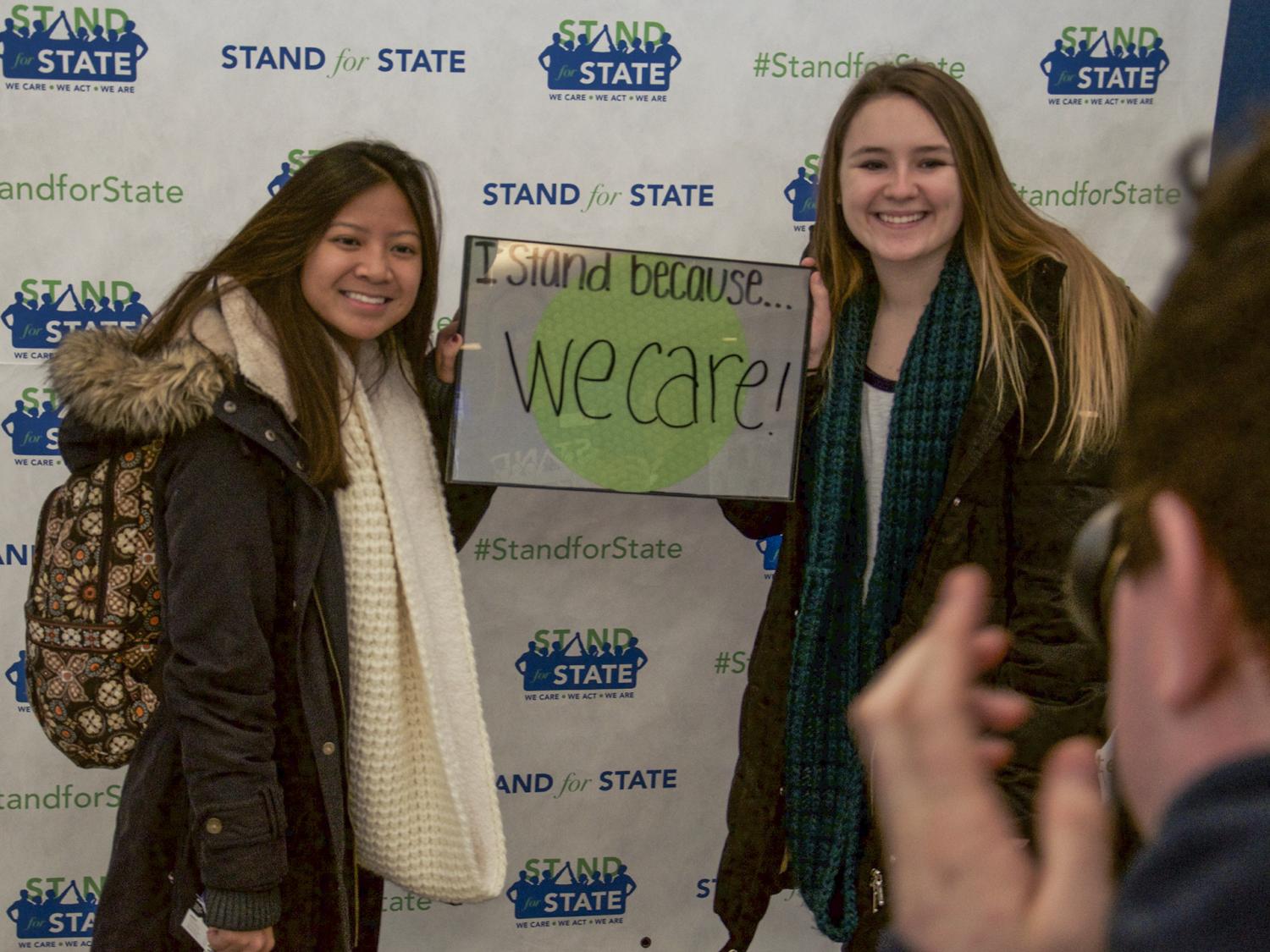 Two students posing with a sign 