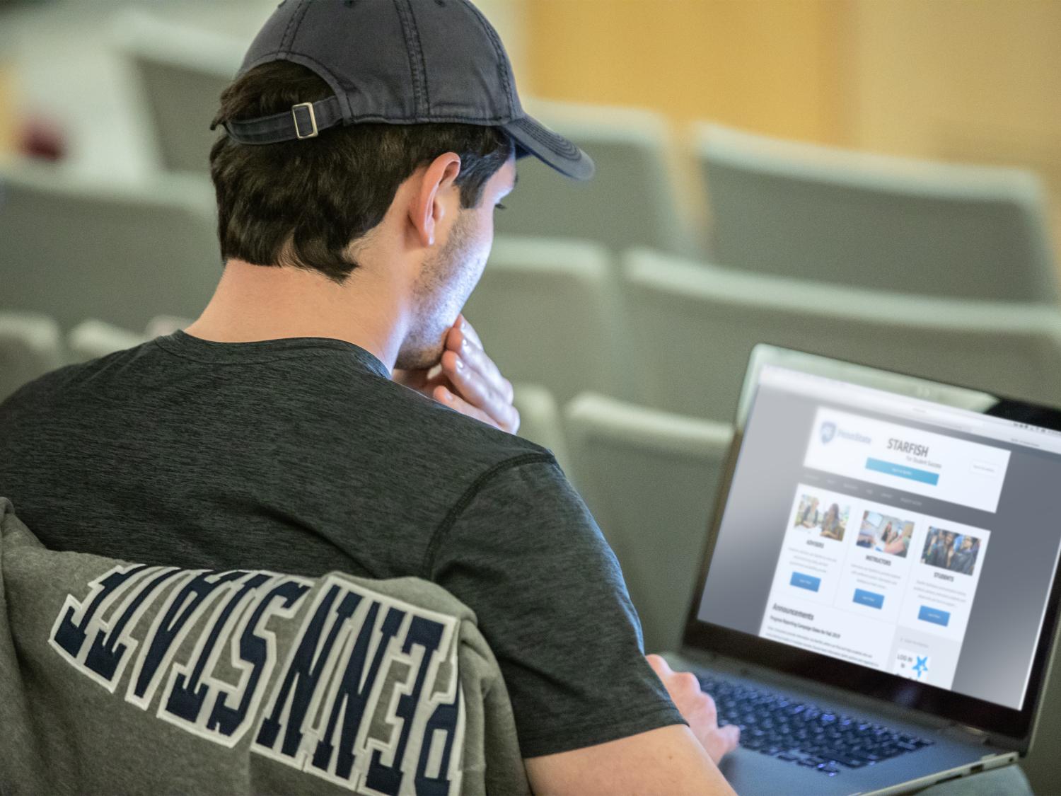 Student in a classroom accessing the Starfish website on a laptop.