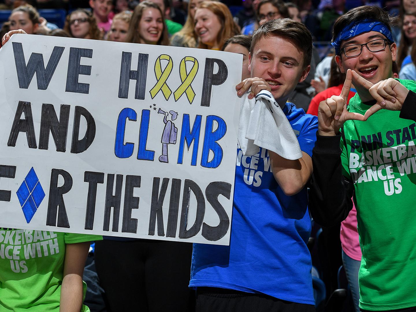 Students hold a sign and show support for THON