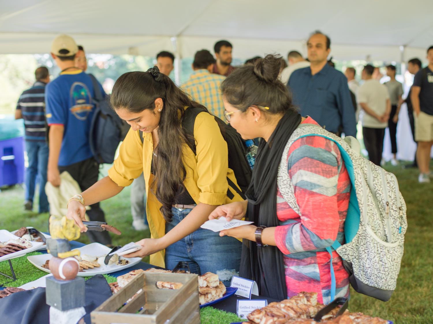 A group of students gathered around a table with grilled stickies
