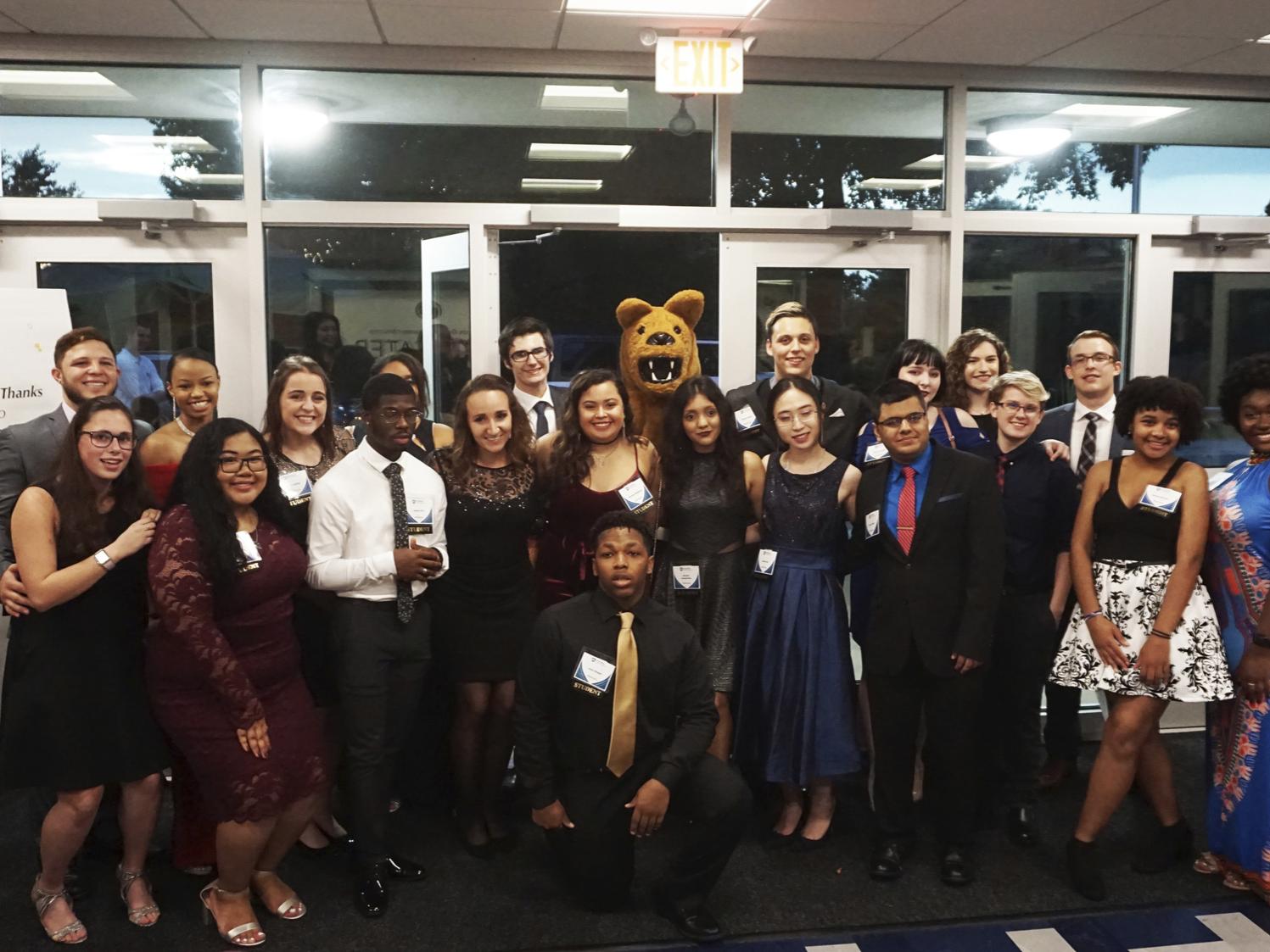 Greater Allegheny Students standing next to mascot in front of doorway