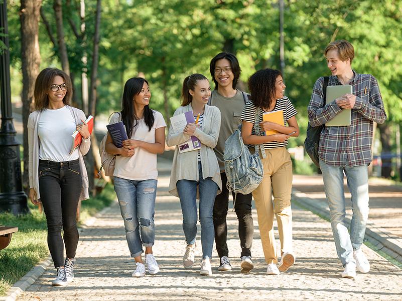 Six students walk outdoors on a college campus