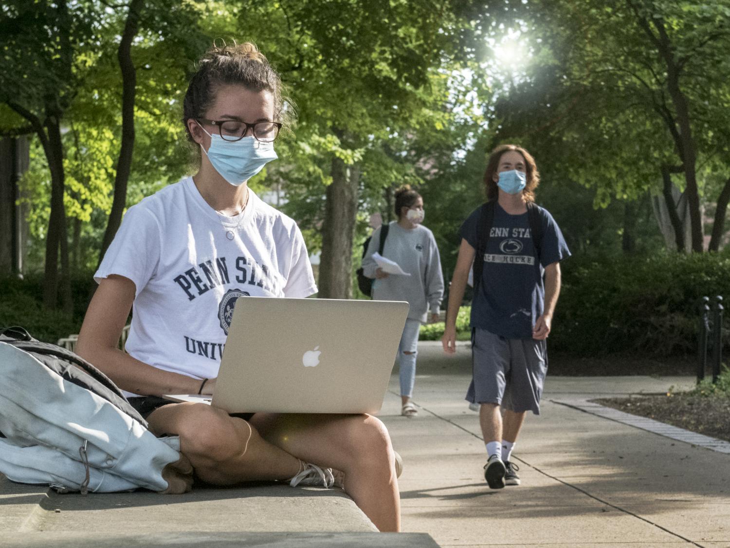 Students in front of Old Main wearing masks