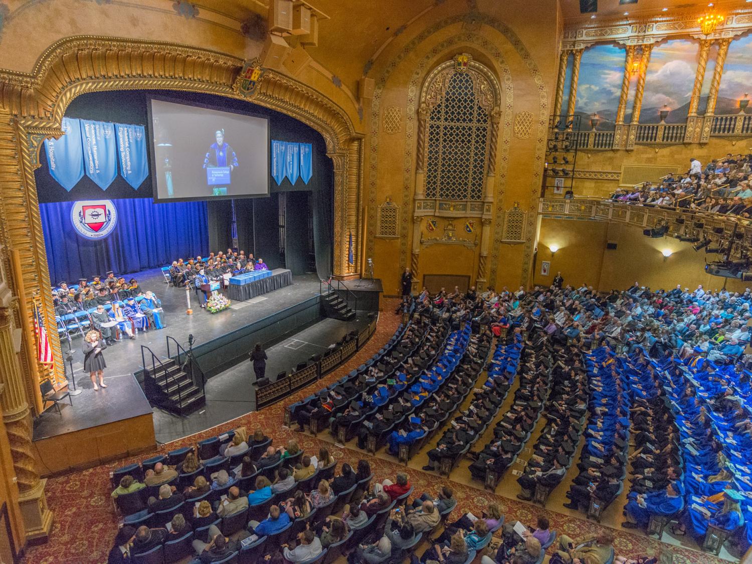 A group of students at a graduation ceremony in an auditorium.
