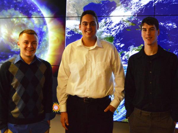 Jacob DeFlitch, left, Ben Reppert and Steve Hallett stand in front of the weather wall in the Myers Weather Center in Walker Building on Penn State's University Park campus. 