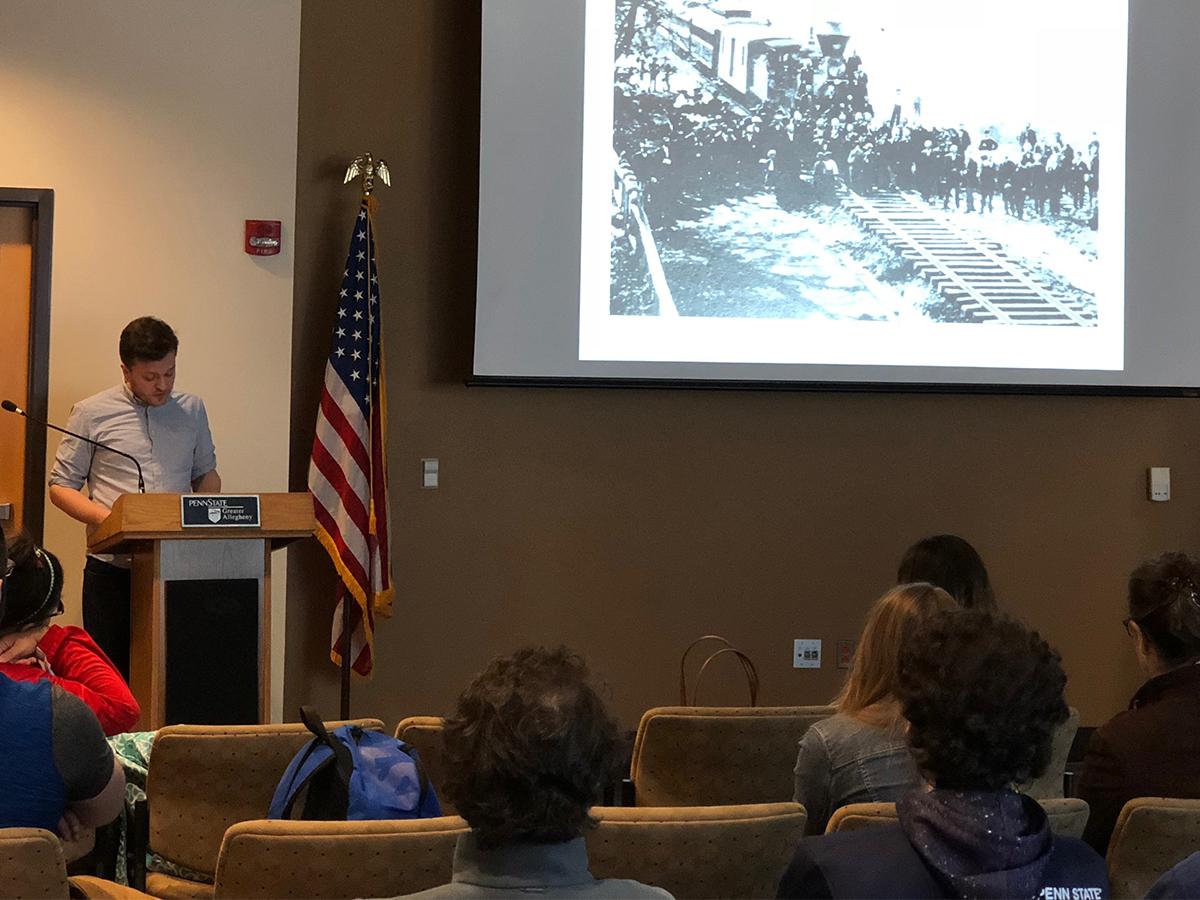 Presenter discussing current slide of old Pittsburgh to students 