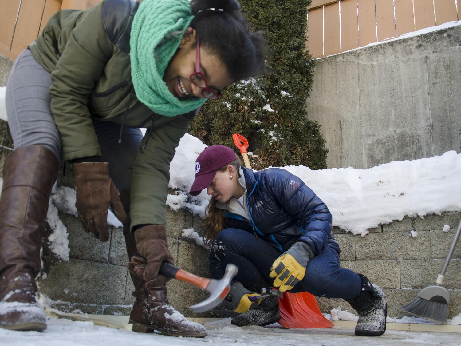 Two students removing pieces of a shed
