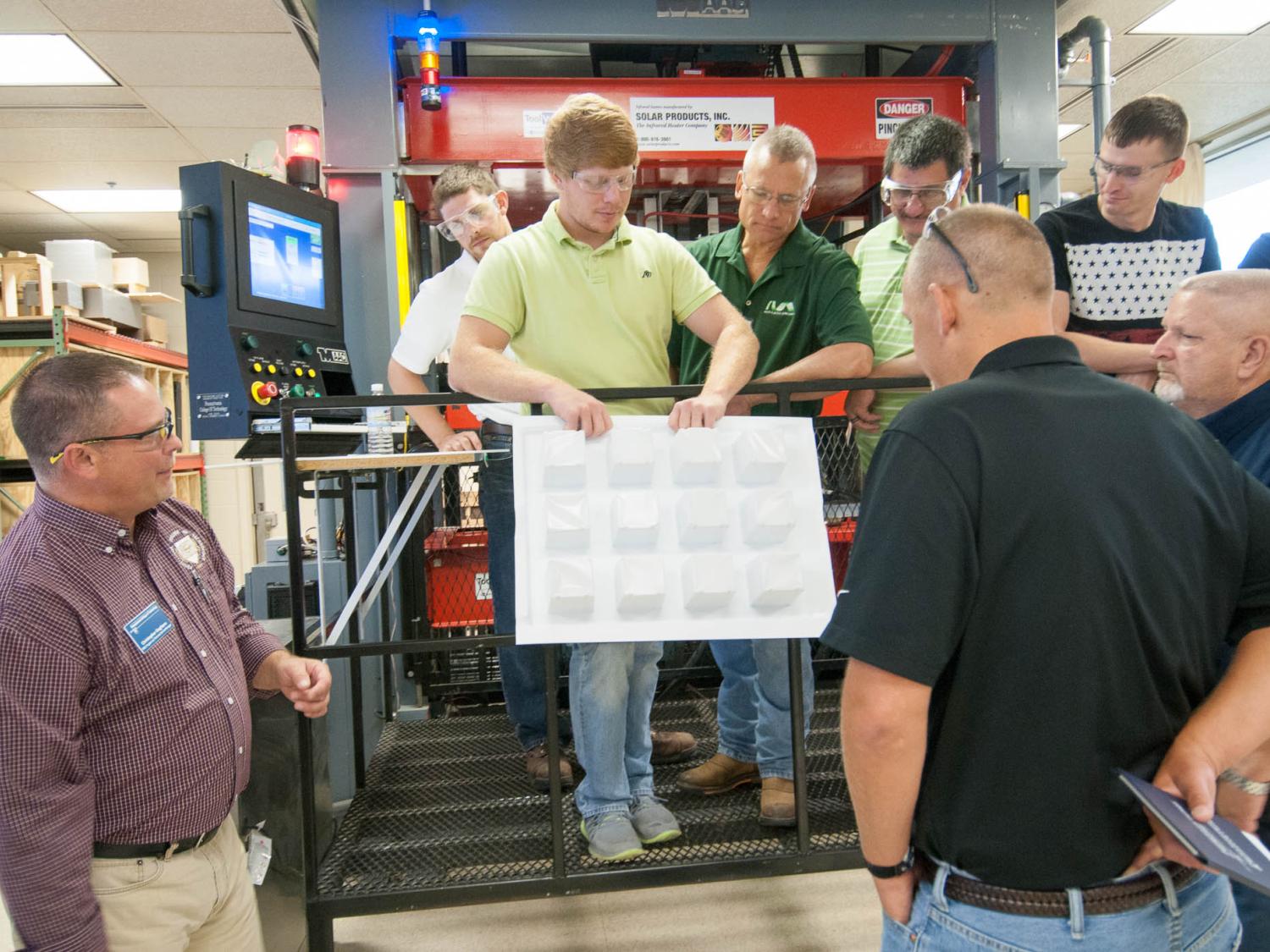 The wall thickness of a container produced in the thermoforming lab being examined