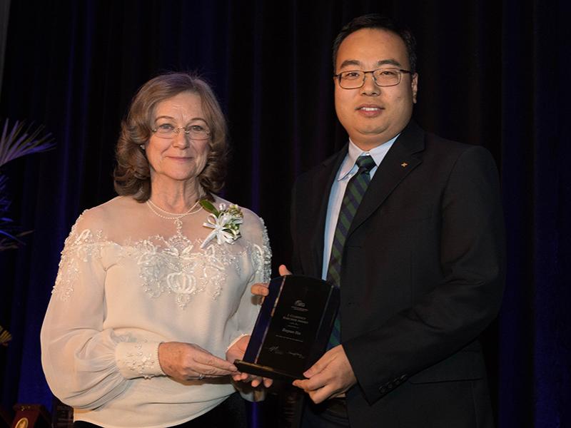 Society of Exploration Geophysicists president, Nancy House, presenting Tieyuan Zhu, assistant professor of geophysics, with the 2018 J. Clarence Karcher Award.