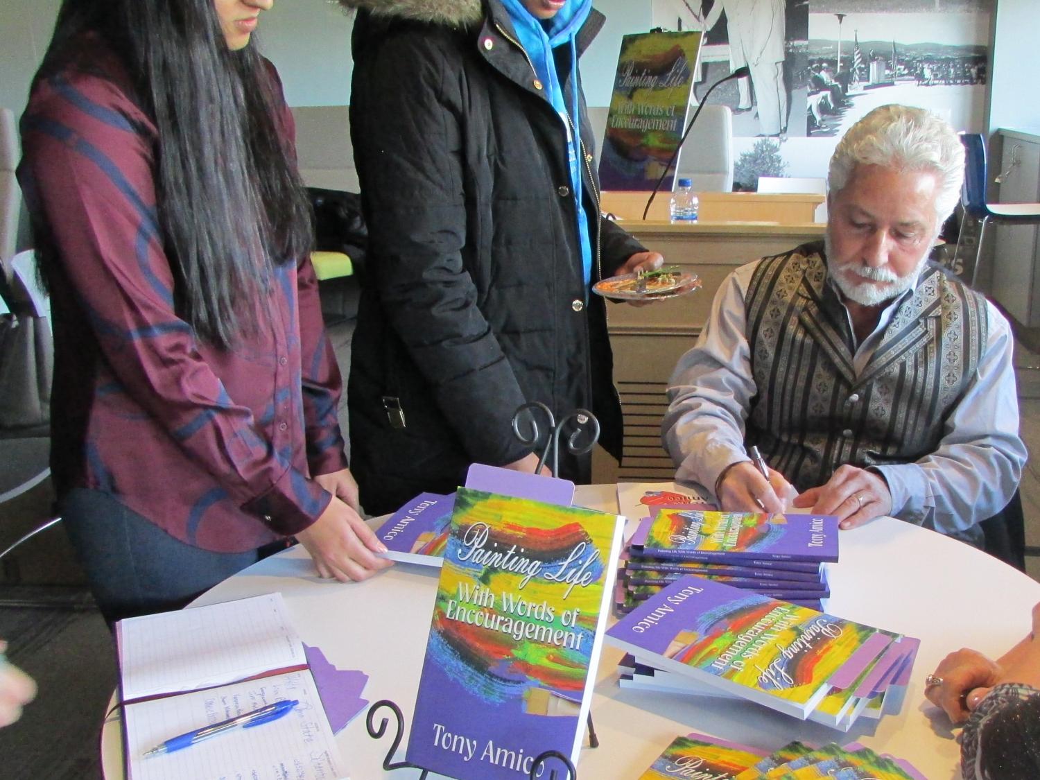 Tony Amico signing books for students