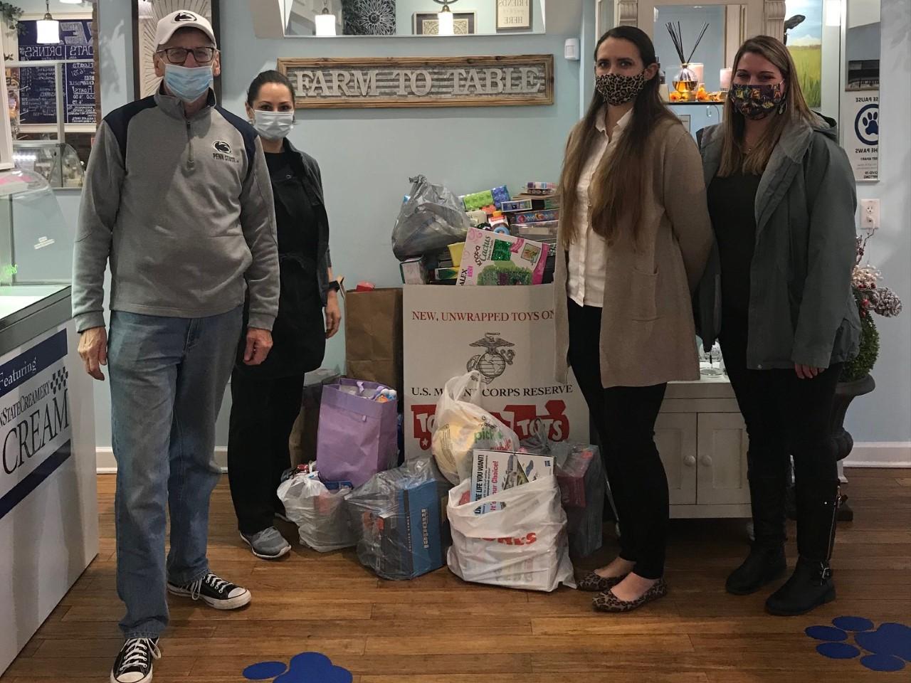 Individuals stand near donated toys