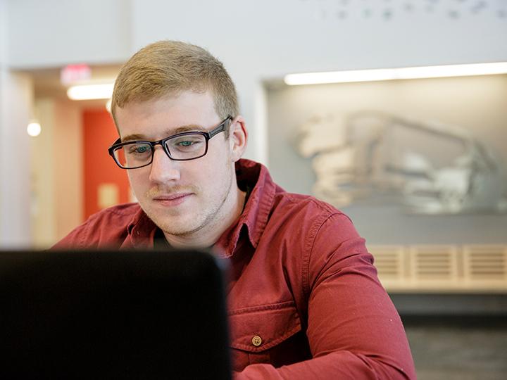 Berks student focusing on his studies in the library. 
