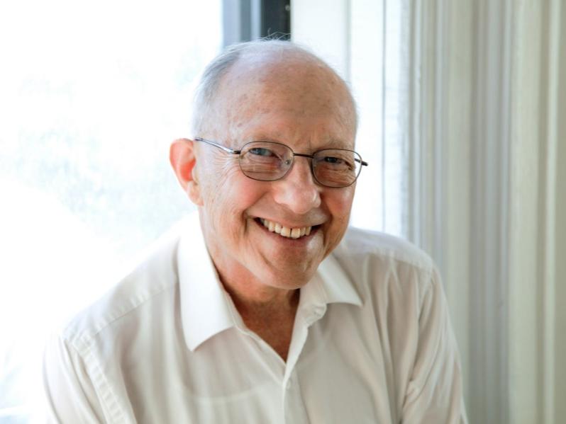 A bespectacled man smiles for the camera.
