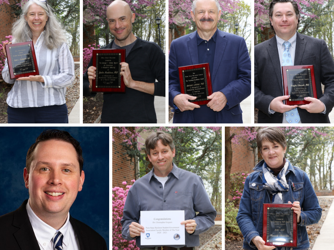 Group of Penn State Hazleton staff and faculty holding plaques outside on campus mall.