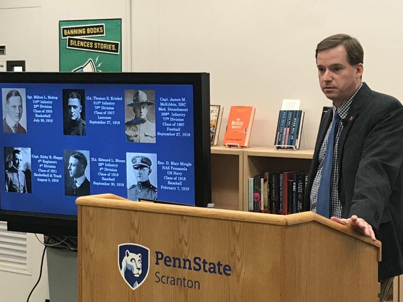 Ken Hickman, director of the Penn State All-Sports Museum stands at podium in library