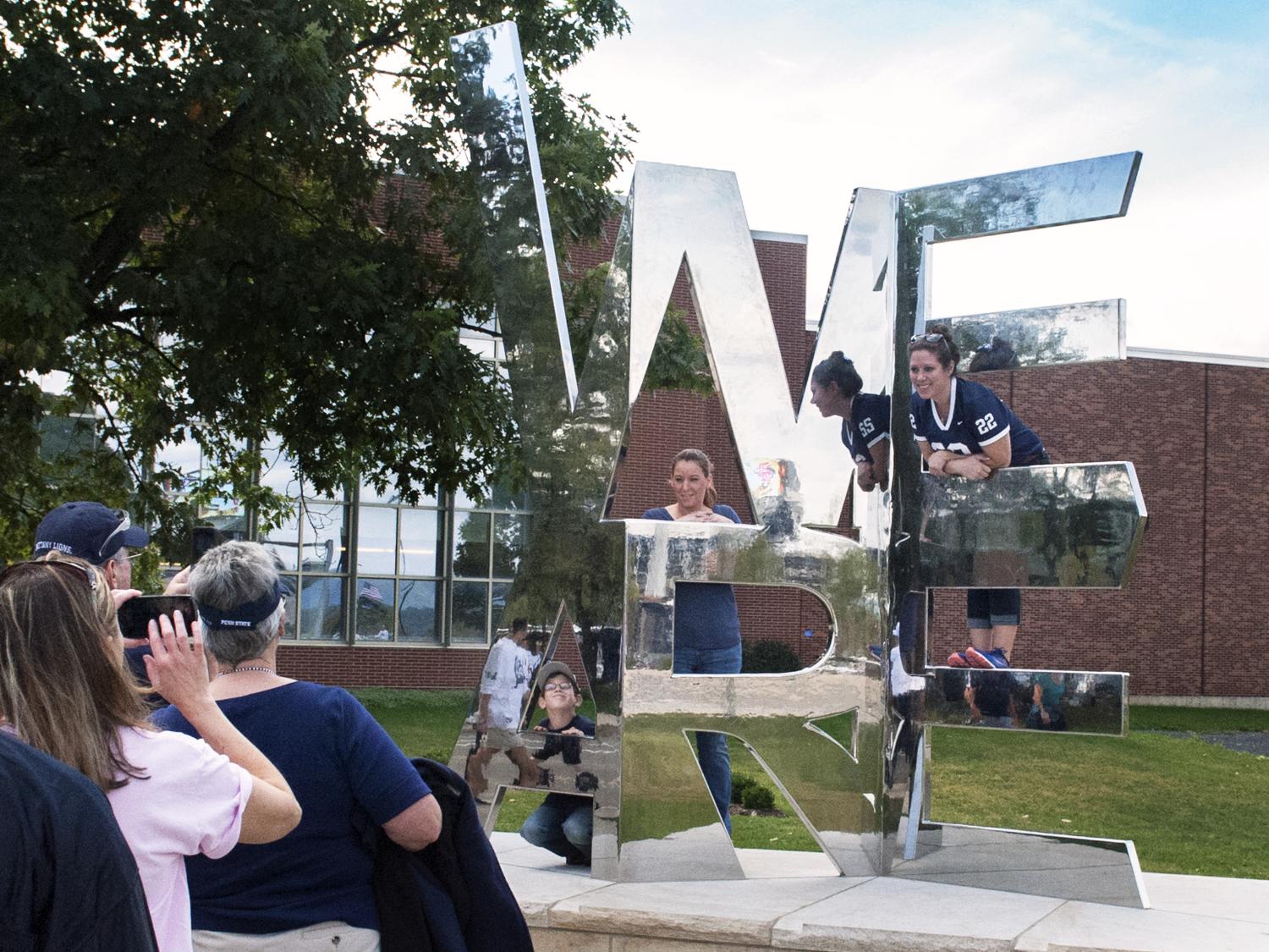 Visitors taking photos at the We Are sculpture