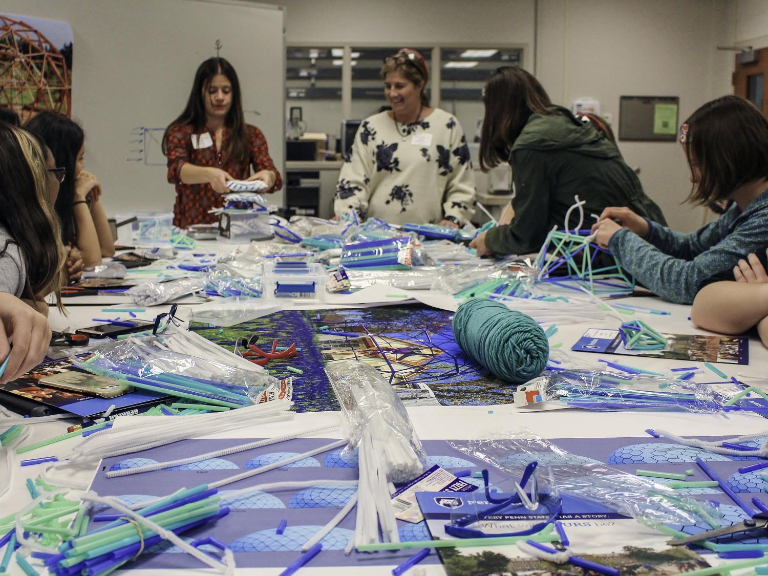 A group of students builds pipe-cleaner structures during the Women in Engineering Day program at Penn State Behrend.