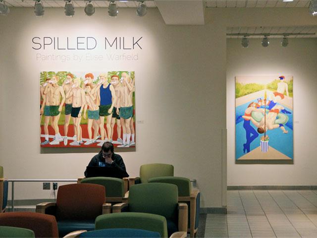 Photograph of two of Warfield's paintings. One shows a group of high school-age boys drinking milk before a track & field event. The other shows a group of young adults lazily enjoying a pool.