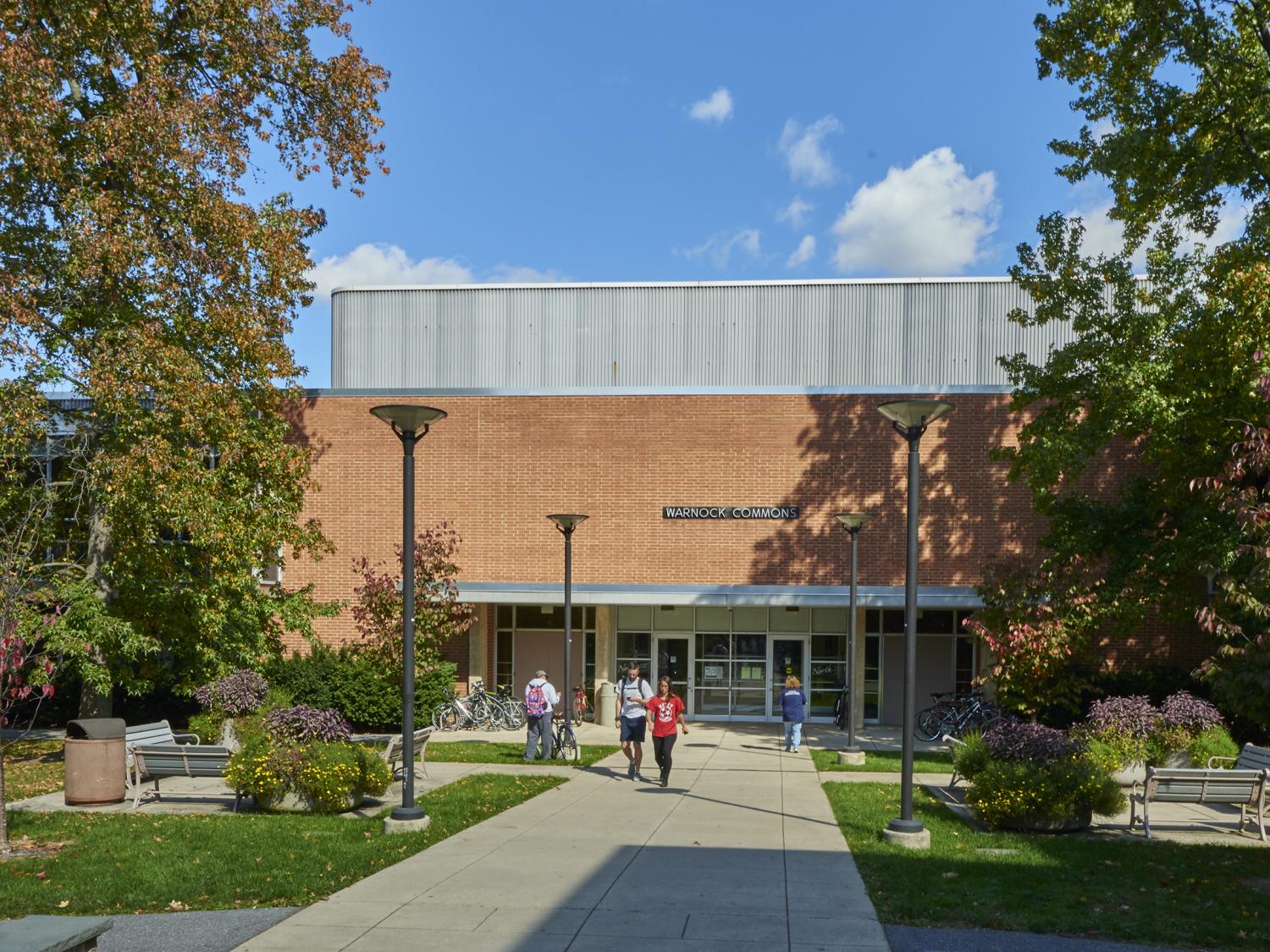 Students walking outside of Warnock Commons on a fall afternoon. 