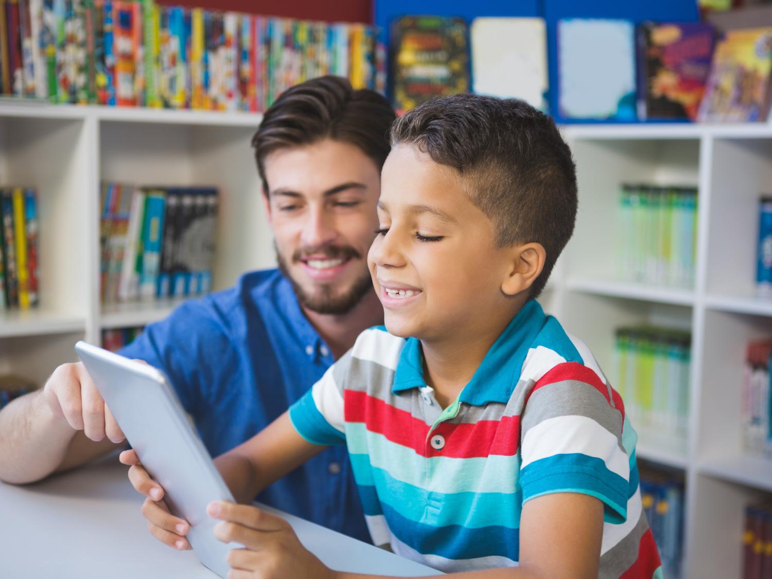 Teacher with student using tablet