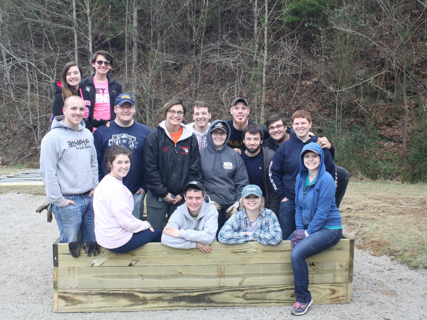 Students pause for a photo inside one of the community garden planting boxes they constructed. 