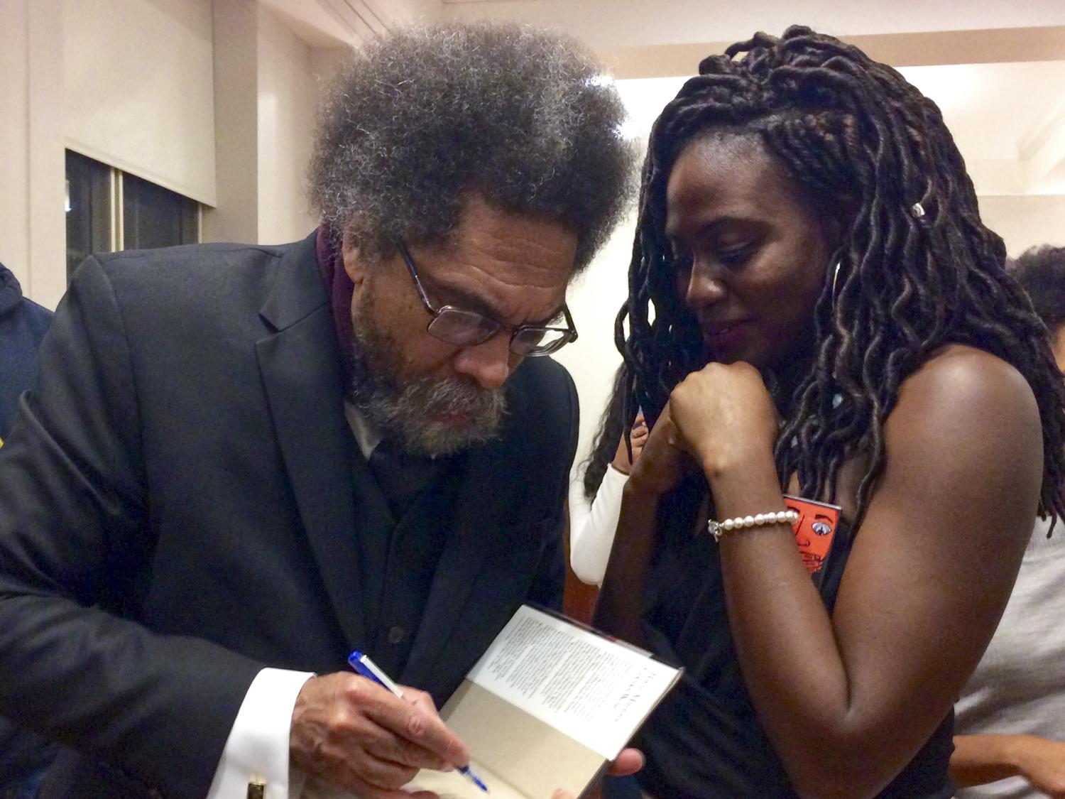 Cornel West signing a book for a student