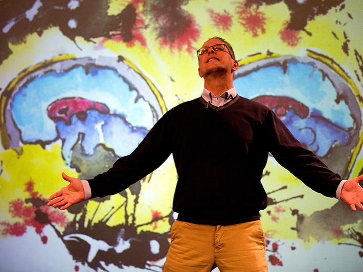 William Doan giving a presentation with his artwork projected in the background