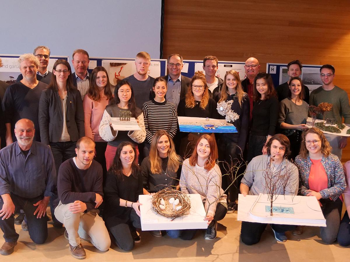 The five finalist groups of students pose with their designs, their clients and the instructors of their studio.