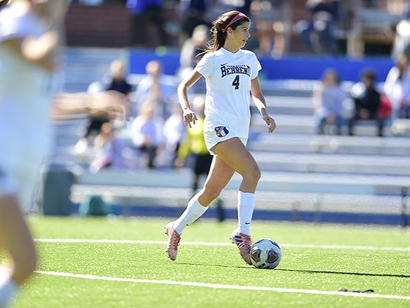 A Penn State Behrend soccer player kicks the ball.