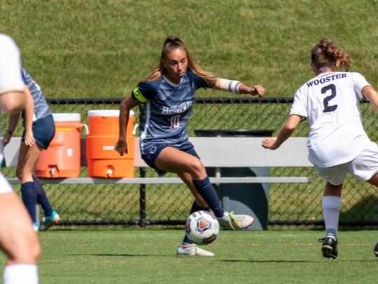 A Penn State Behrend soccer play dribbles the ball upfield.
